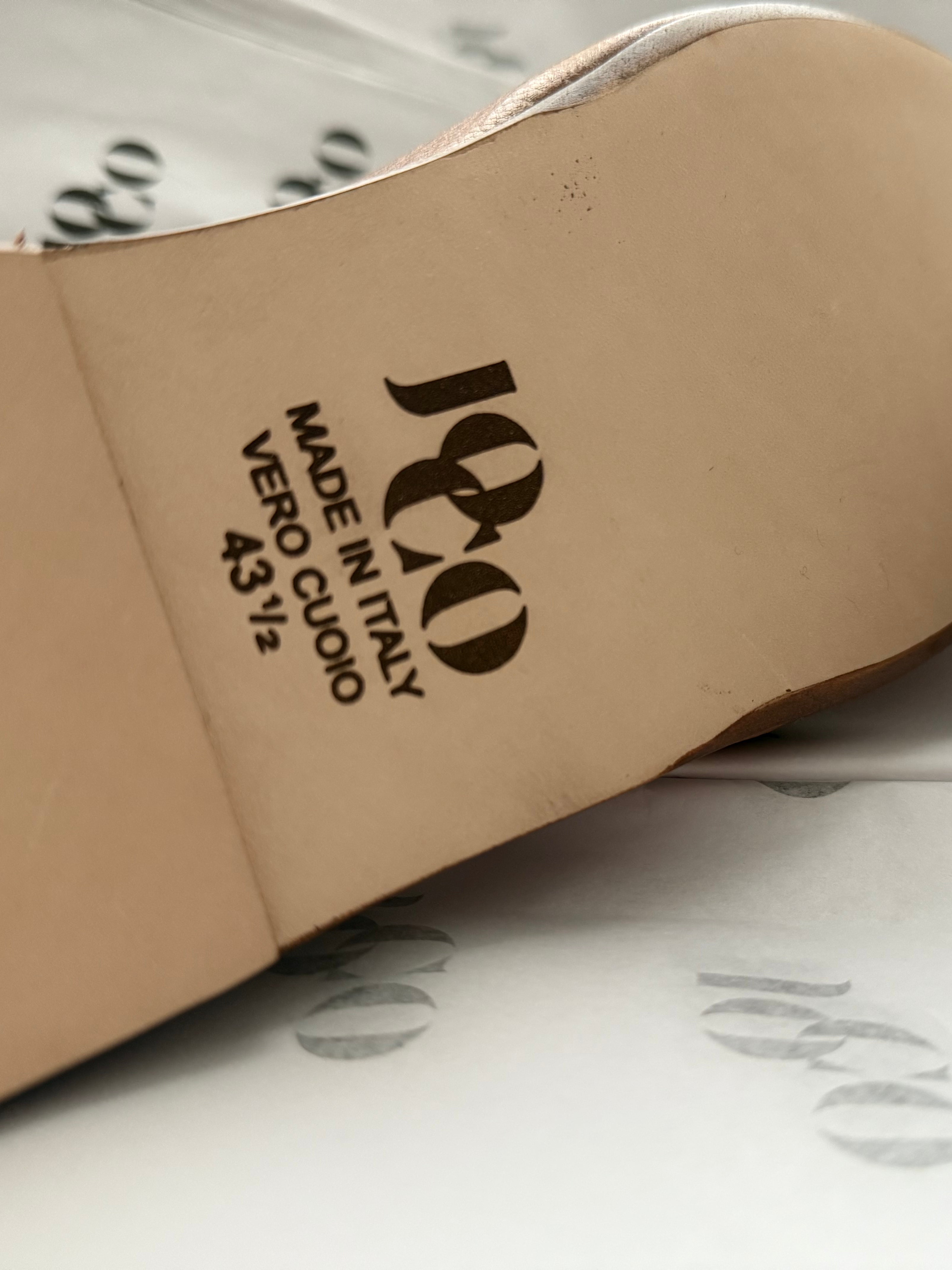 Close-up of a brown leather shoe with 'JOCO ' branding on a branded paper background. Made in Italy luxury Rajasthani Mojri Loafers