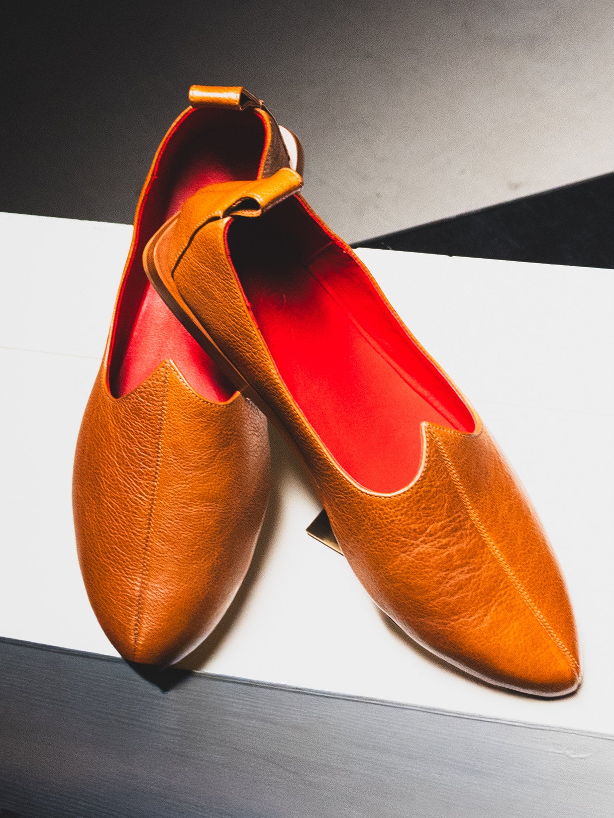 Handcrafted Brown loafers with red interior on a white background. Designer  Rajasthani Mojri made in Italy.