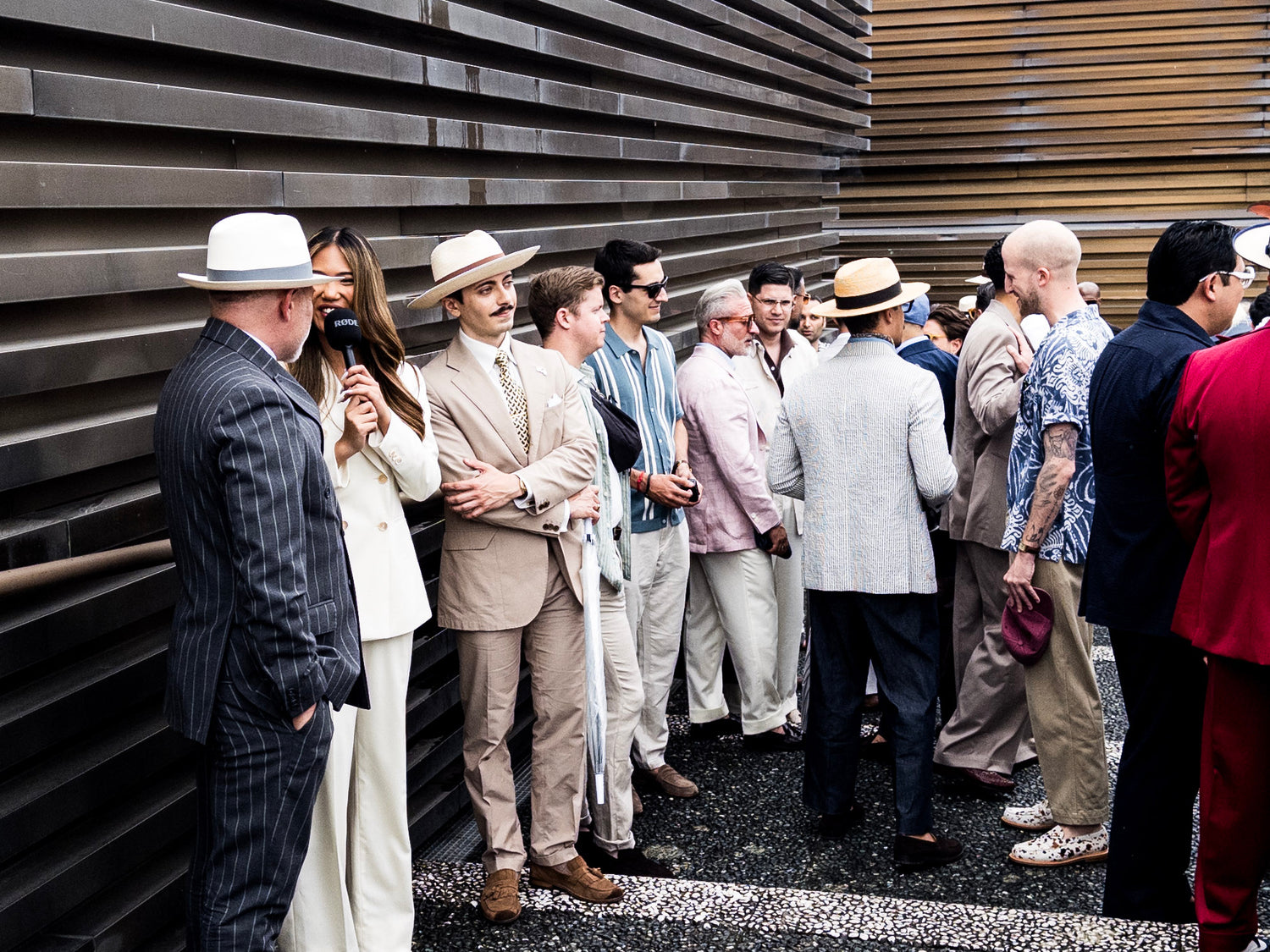 Group of men in vintage attire standing against a metallic wall at Pitti Uomo Florence, Italy. 